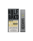 The Half Bak'd Sauced Private Reserve Disposable, a 1g vape labeled "SAUCED," is paired with a box of "Half Bak'd Private Reserve Super Lemon Haze," offering a sativa strain that enhances your experience with the Entourage Effect for a full-spectrum sensation.