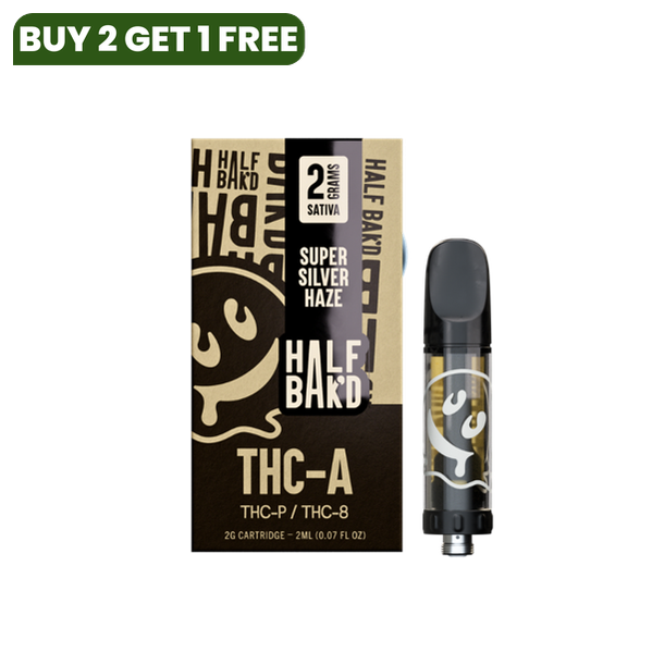 A Half Bak'd Half Bak'd THC-A Cartridge | 2g in Super Silver Haze flavor, containing 2 grams of Sativa and compatible with 510 vape batteries. The black and gold box, along with the cartridge, features a smiling face logo. Enjoy a premium THC-A live resin experience.