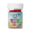 A transparent jar with a white lid contains red gummy candies labeled "Torch Haymaker Blend Gummies, 3500mg." The colorful label features fireworks graphics.