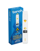 A sleek white vape pen lies next to its blue "Torch THC-A VVS Diamond Blend Disposable | 1g" packaging labeled "Berry Blue," featuring a yellow accent, highlighting Torch's commitment to premium quality.