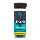 A clear cylindrical container labeled "Torch Nitro Blend XXL Gummies | 7000mg" from the brand Torch contains rainbow snow cone flavored THC gummies with live resin. It has a black screw cap and a prominent high dose warning label at the bottom.
